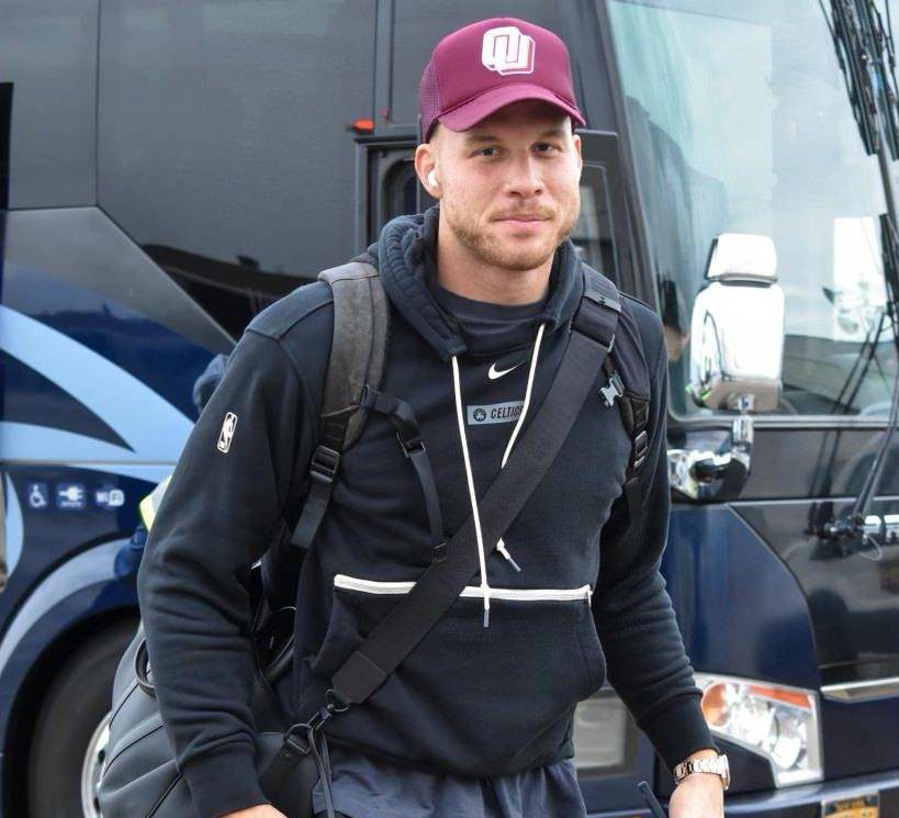 Man In Maroon Cap And Black Hoodie Next To A Bus